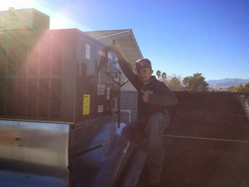 HVAC technician performing AC Tune-Up on a rooftop unit in Cary